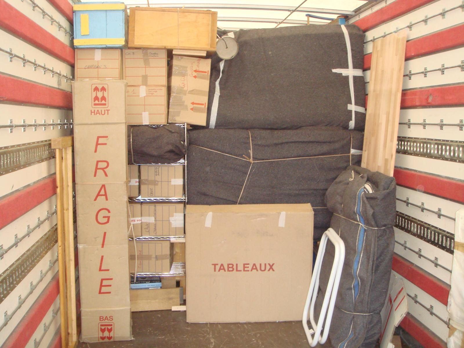 Camion capitonné chargé avec cartons fragiles, tableaux et meubles sous couvertures