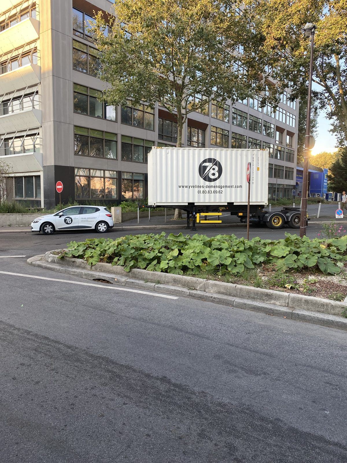 Conteneur et véhicule Yvelines Group devant un immeuble de bureaux