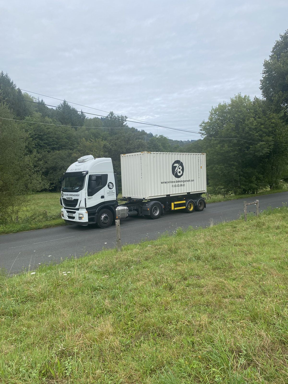 Tracteur Iveco Yvelines Group et conteneur sur une route de campagne